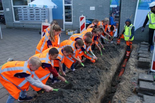 Directeur OBS De Hasselbraam zet eerste schop in de grond voor aanleg glasvezelnetwerk.